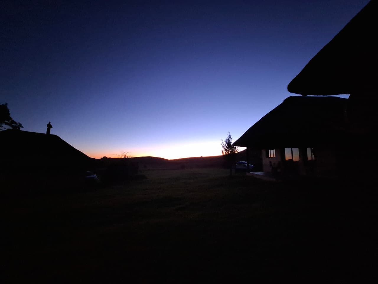 Dusk silhouette of the lodge against Drakensberg sky